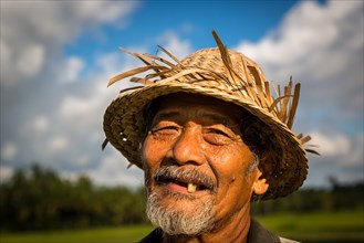 Elderly rice farmer wearing a straw hat