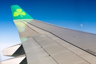 View of an Aer Lingus airplane wing and the moon during a transatlantic flight