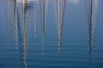 Boat masts reflecting in the sea