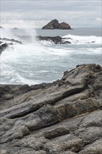 Waves breaking on the coast of Chinaman's Hat island off Santiago Island