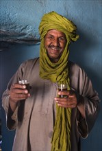 Tuareg man serving tea in his house