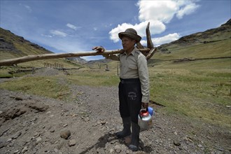 Farmer with wooden plow and teapot on the way to the field work
