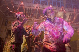 Devotees covered in coloured powder celebrating