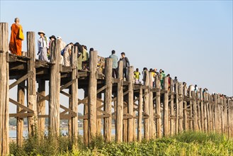Locals and tourists on a teak bridge