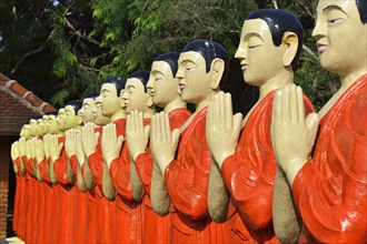Figures of Buddhist monks in front of a monastery