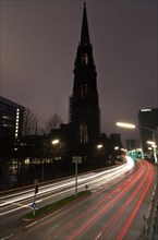 Street scene with light trails and the silhouette of the St. Nicholas' Church
