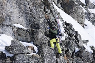 Freeride skier ascending the Winterklettersteig climbing route