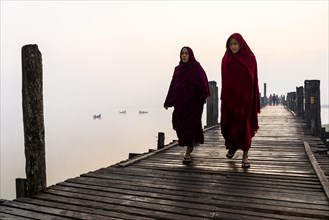 Monks walking on a teak bridge