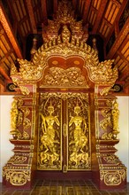 Teak entrance gate decorated with gold leaf in Wat Phrah Singh Temple