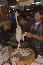 Butcher with a chicken on the market