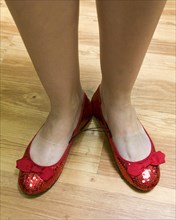 A woman's feet with red ruby slippers