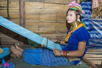 Long-necked woman weaving