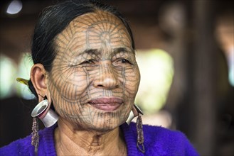 Woman with a traditional facial tattoo and ear jewelry
