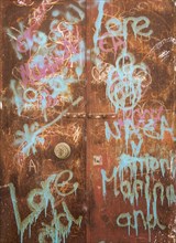 Drawings and writings on a rusty door