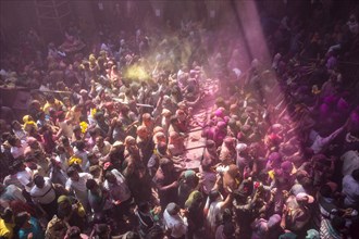 Devotees celebrating and throwing coloured powder