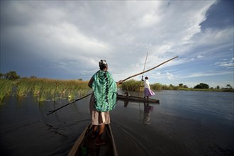 Boatman with a typical pole on a traditional mokoro boat