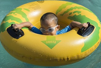 Boy playing with a floating tire