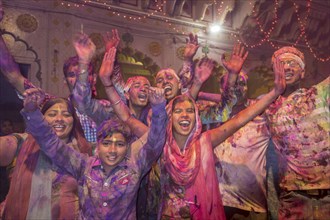 Devotees covered in coloured powder celebrating