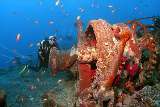 Scuba diver looking at winch of shipwreck 'SS Thistlegorm'