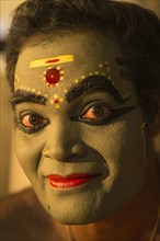 Kathakali dancer in full makeup waiting for his performance