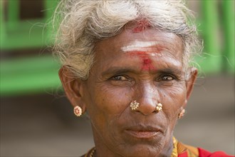 Elderly local woman with a bindi on her forehead wearing gold jewelry