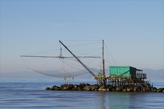 Fisherman's house with a net over the sea in Marina di Pisa