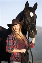 Young woman with a black Hanoverian horse