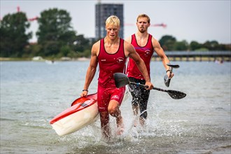 Two kayakers carrying a kayak