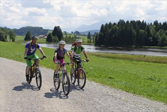 Cyclists on bike tour on Luimooser Weiher pond in Seeg
