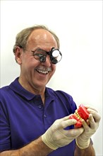 Dentist wearing a headlamp and holding a dentition model