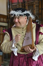 Musician in period costume performing on a medieval psaltery