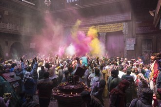 Devotees celebrating and throwing coloured powder