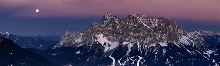 Summit of Mt Zugspitze with a full moon at dusk