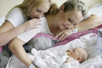Mother in the hospital with her older daughter and a newborn baby