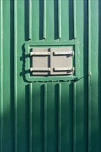 Closed shutters of a green wooden hut