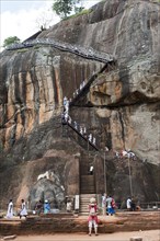 Visitors climbing the steep stairs to the rock fortress of Sigiriya