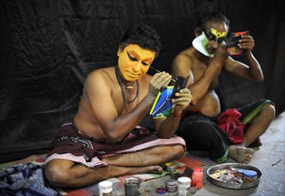 Kathakali actors applying makeup