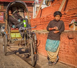 Rickshaw driver and a woman taking a rest