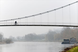 Cyclist crossing a suspension bridge