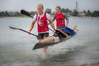 Two female kayakers carrying a kayak