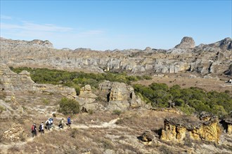 Hikers on trail through rocky landscape