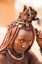 Portrait of a young Himba with traditional jewelry for married women