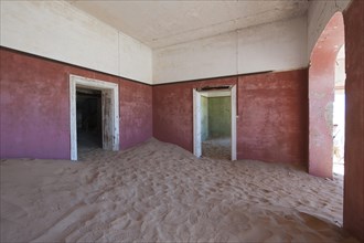 Wind-borne sand in a house of the former diamond miners settlement that is slowly covered by the sand of the Namib Desert