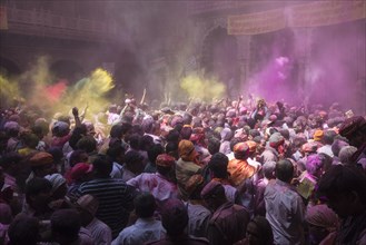 Devotees celebrating and throwing coloured powder