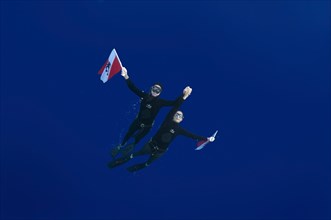 Freedivers holding a diver down flag