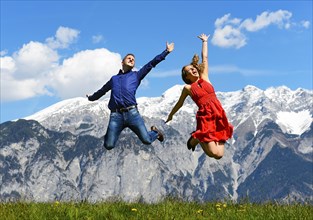 Man and woman jumping on a meadow