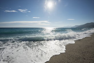 Waves on the beach with the sun