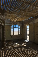 Light passing through the laths of a decaying house in the former diamond miners settlement that is slowly covered by the sand of the Namib Desert