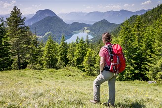 Female hiker observing the view from the Wilder-Kaiser-Steig hiking trail towards Hintersteiner Lake