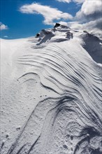 Overhanging snow with wind grooves or Sastrugi ridges